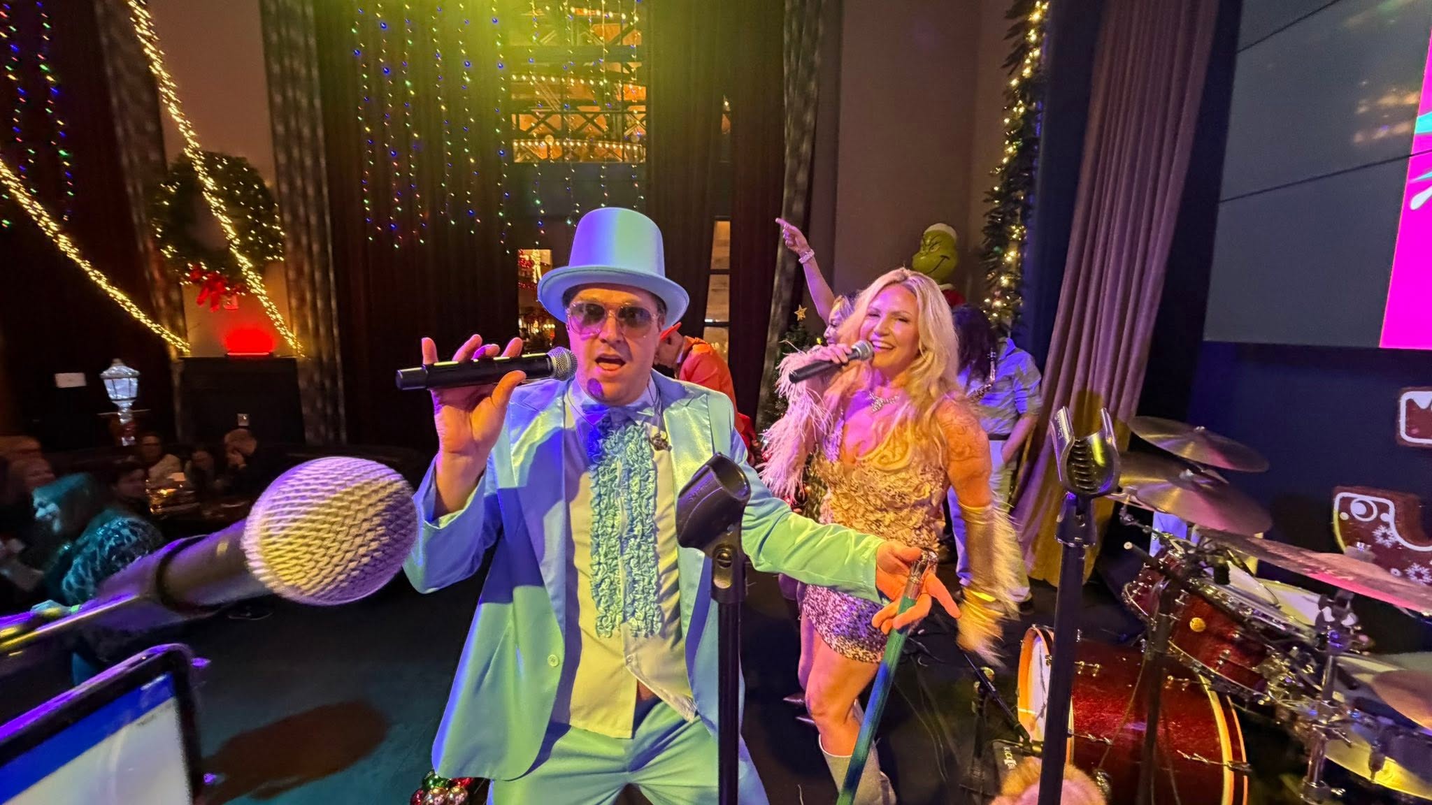 Scott E and Dālene Richelle performing together with Fun & Funner in colorful stage attire.